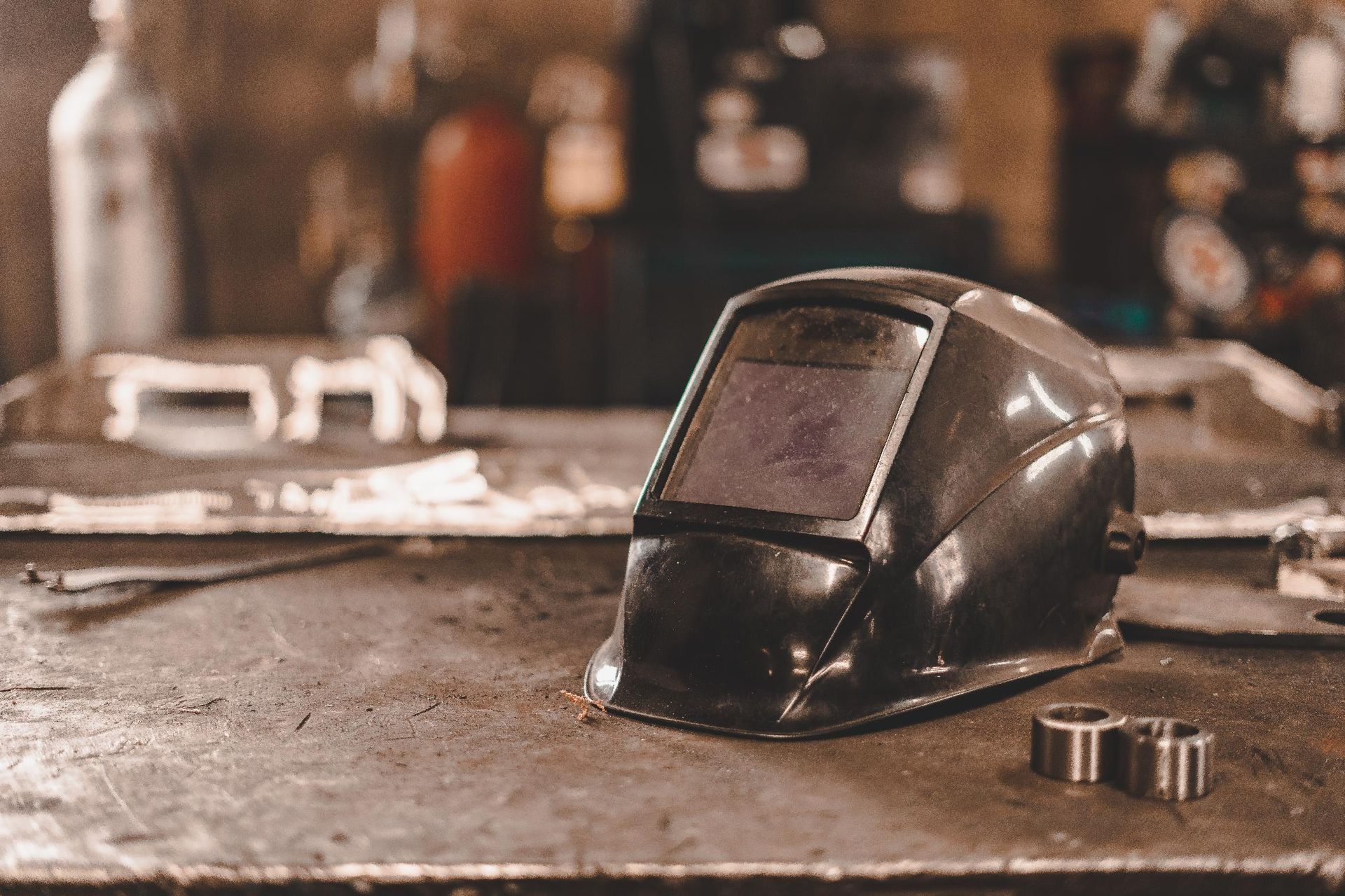 Un casque de soudage est posé sur une table en métal.