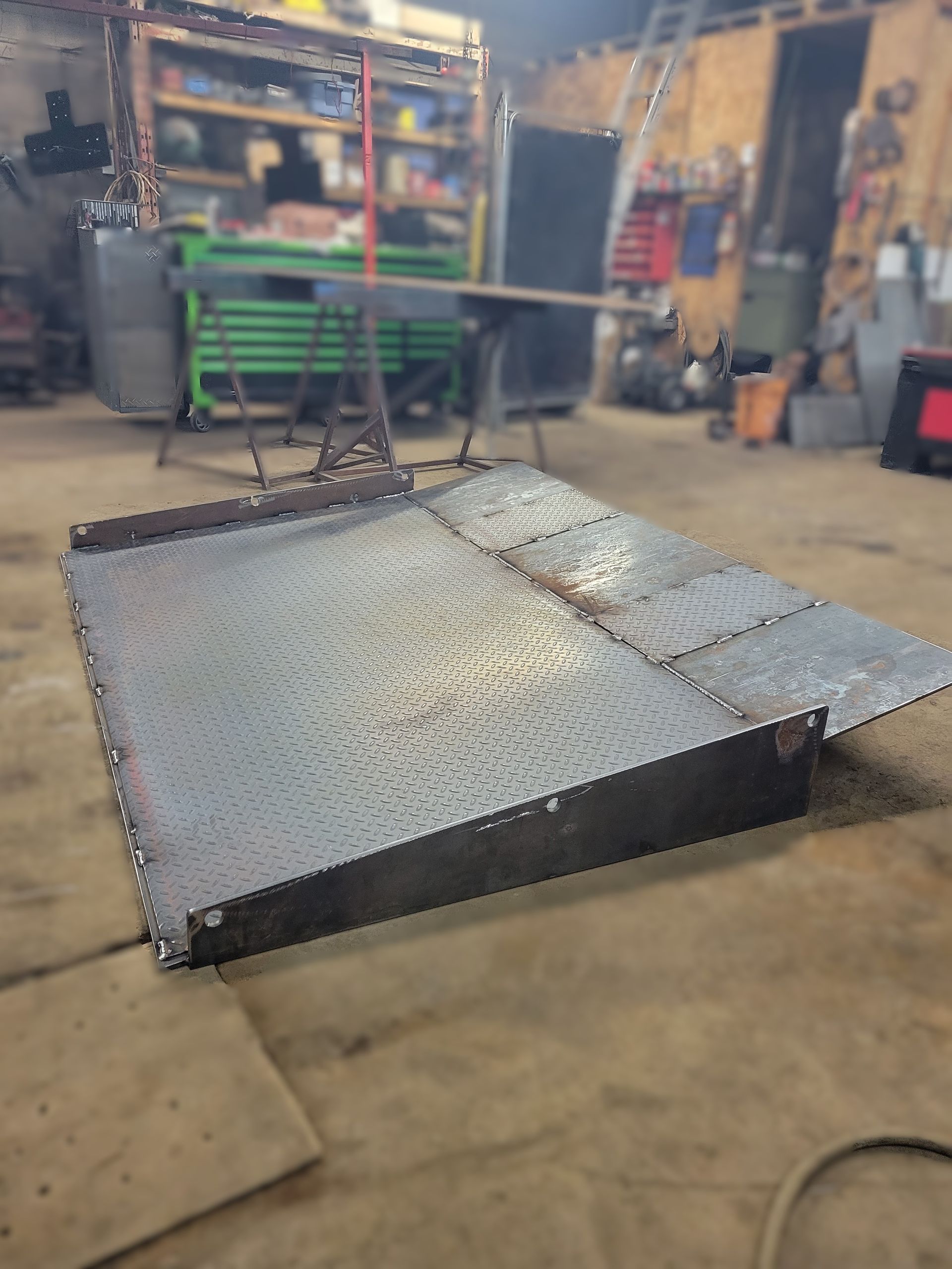 Une rampe métallique est posée sur le sol dans un garage.