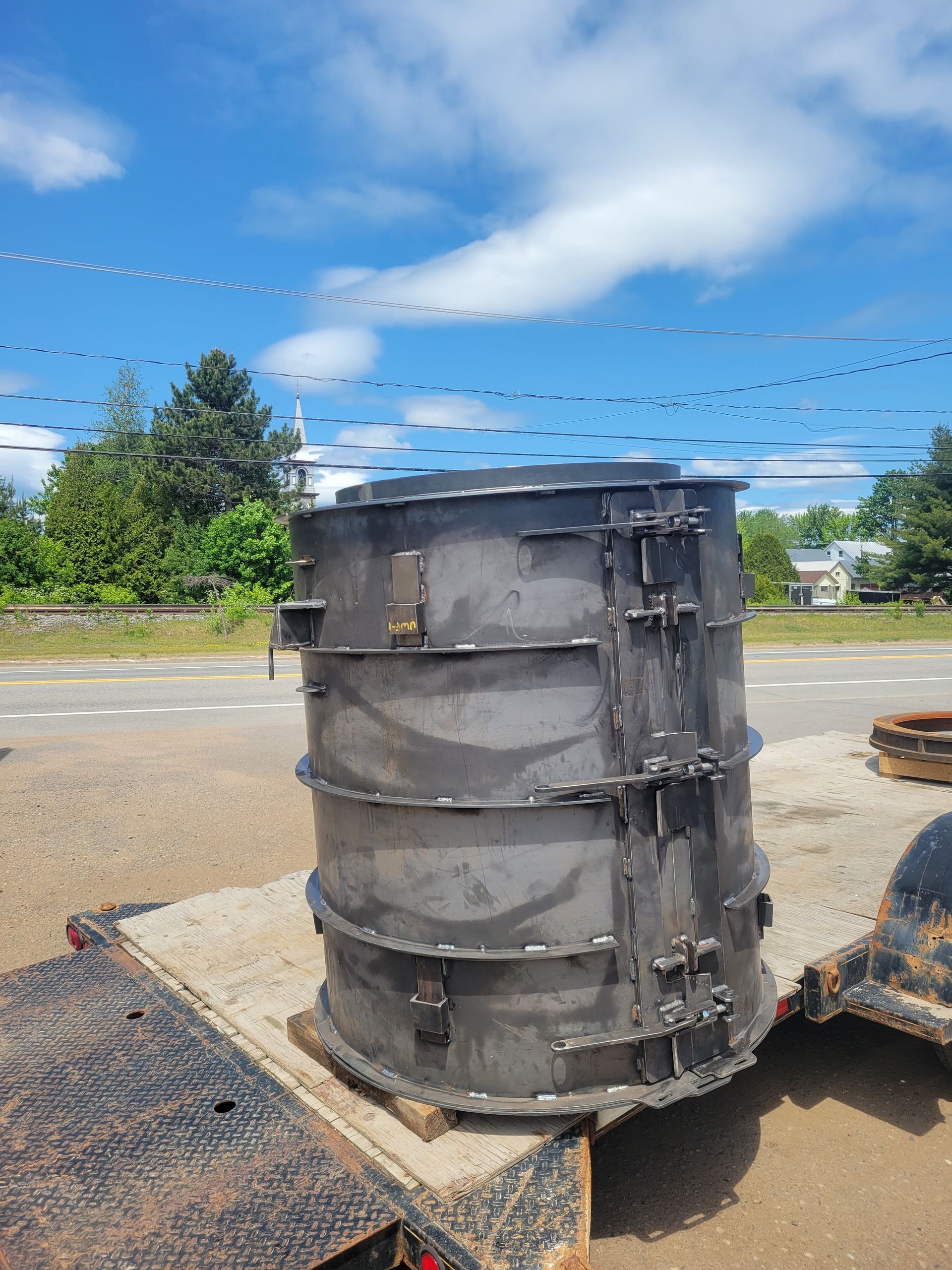 Un gros objet métallique est posé sur une remorque.