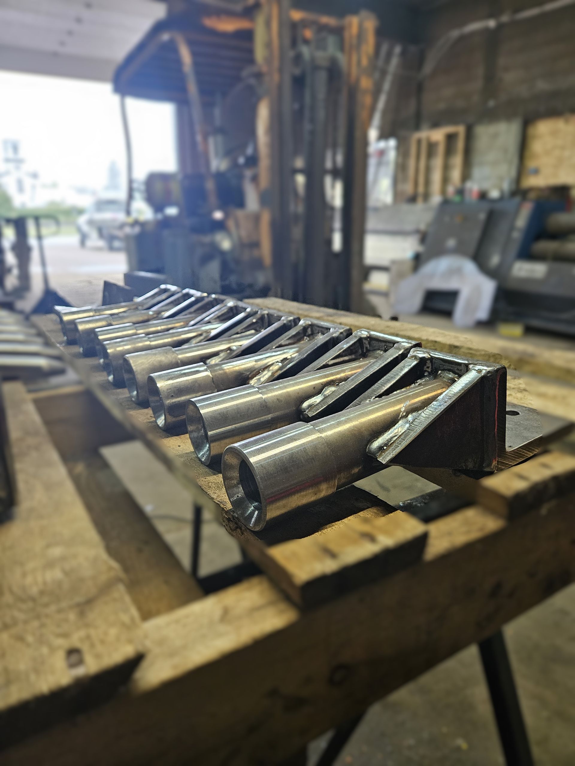 Un tas de pièces métalliques sont posées sur une table en bois.