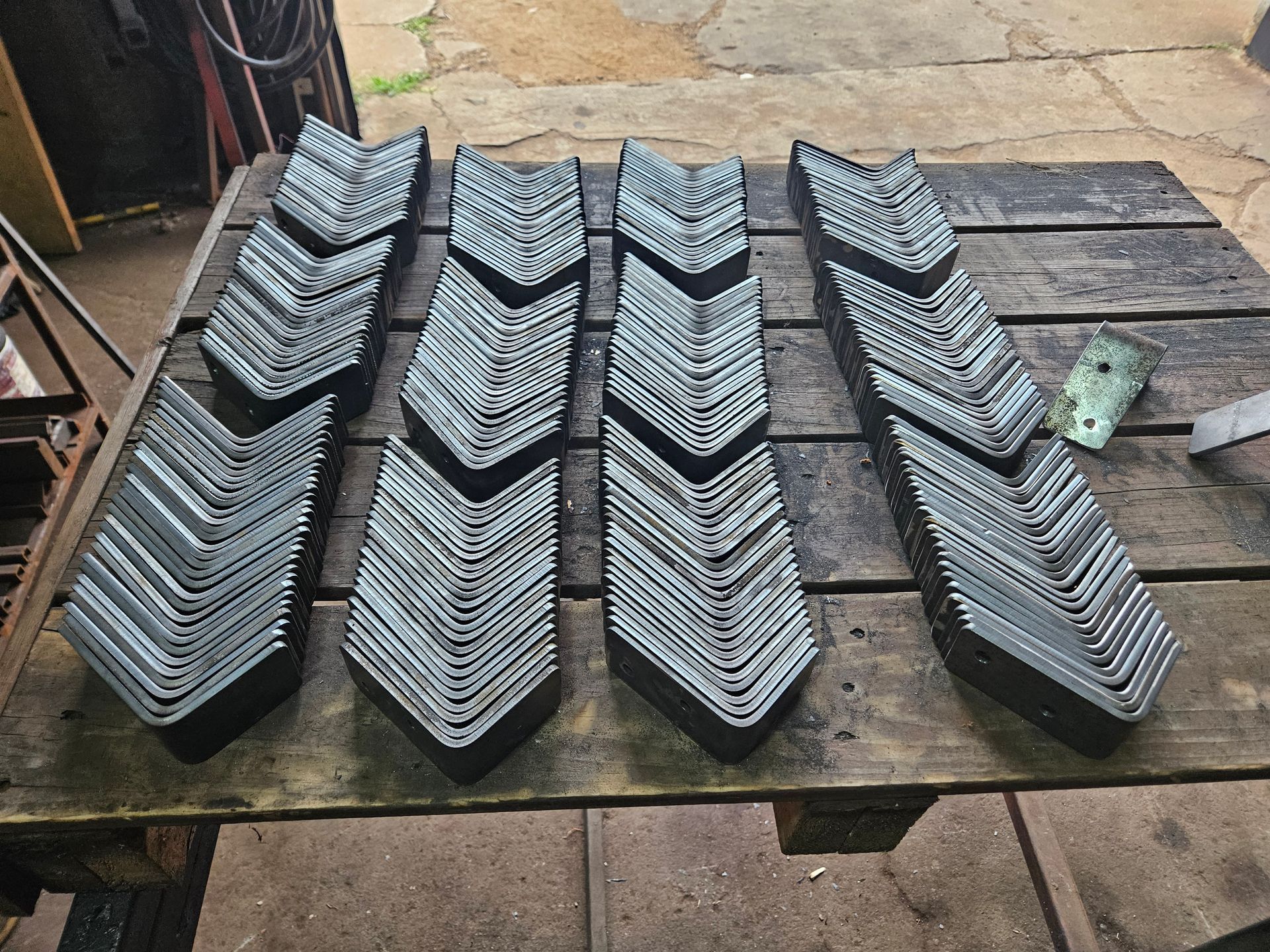 Une table en bois avec un tas de pièces métalliques dessus