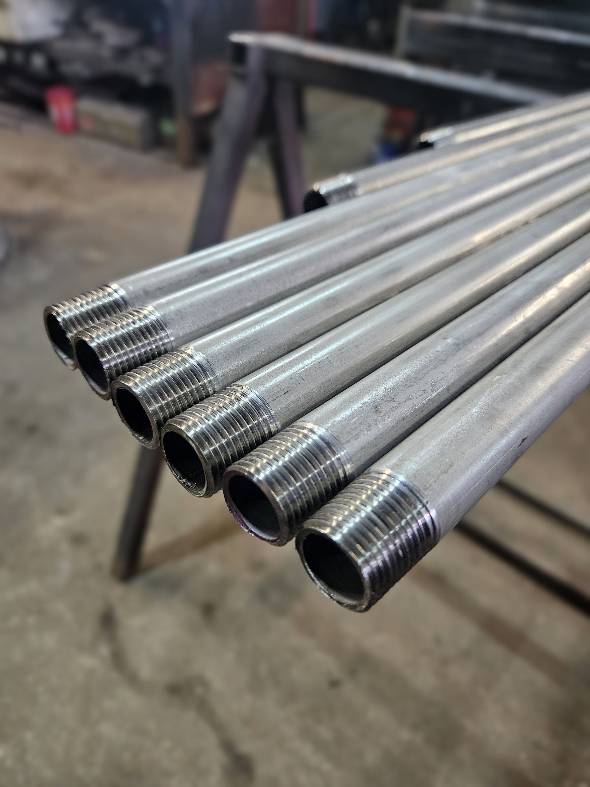 Un tas de tuyaux métalliques sont empilés les uns sur les autres sur une table.