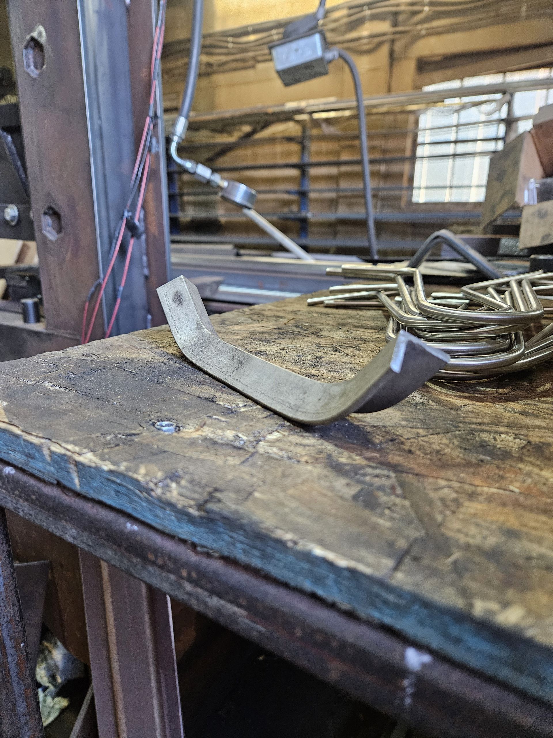 Un morceau de métal est posé sur une table en bois.