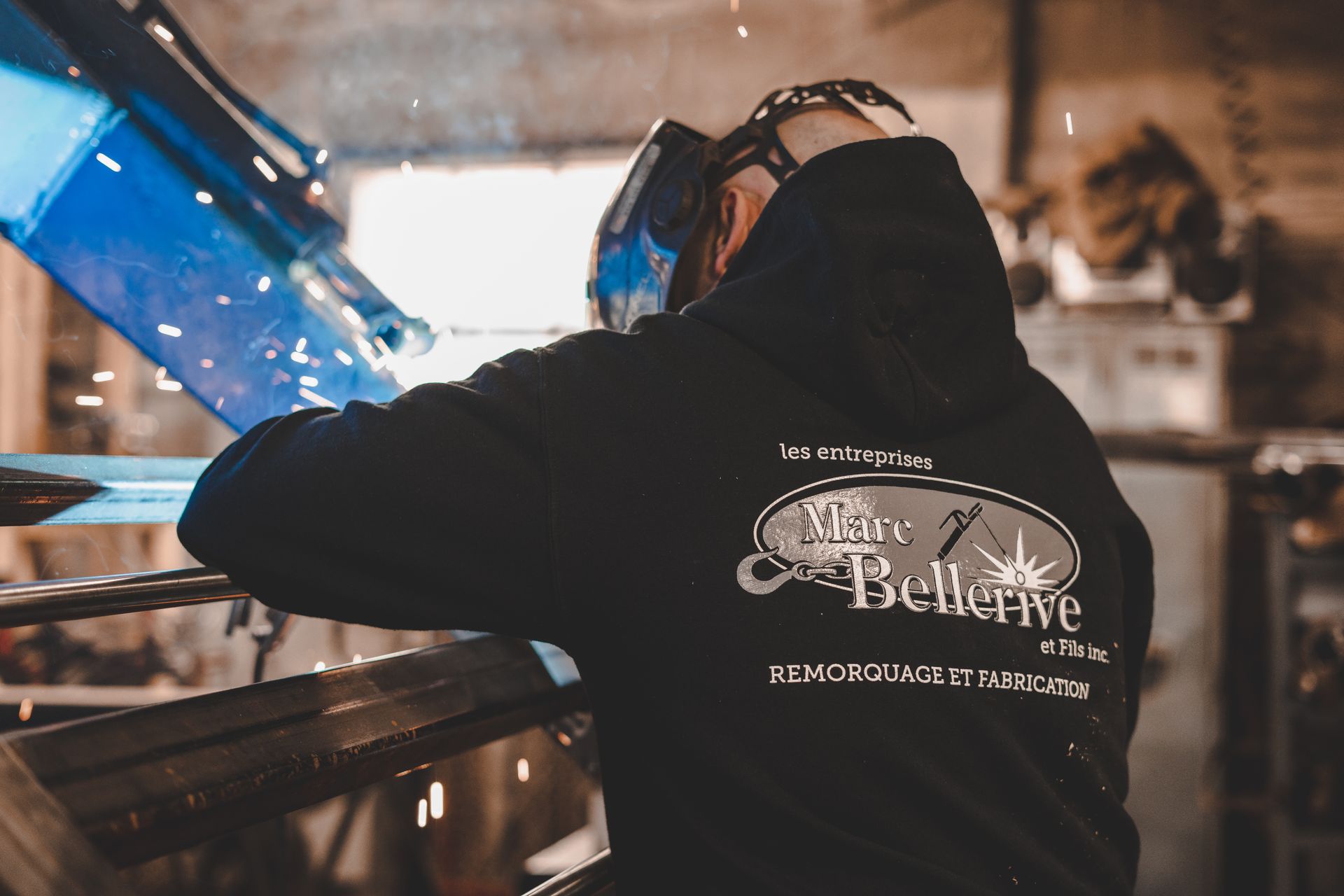 Un homme portant un masque de soudage travaille sur un morceau de métal.