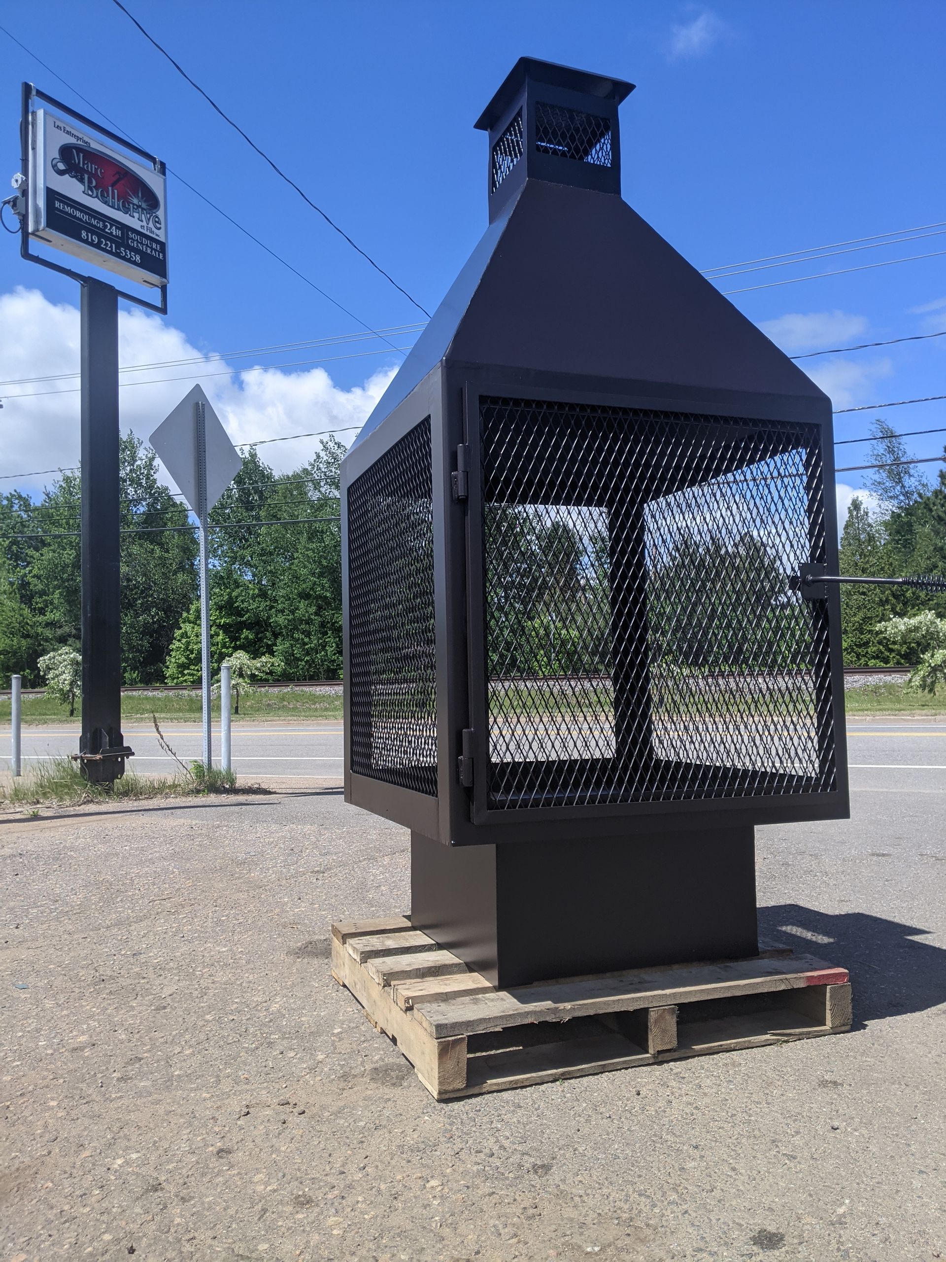 Un foyer est posé sur une palette en bois à côté d'un panneau.