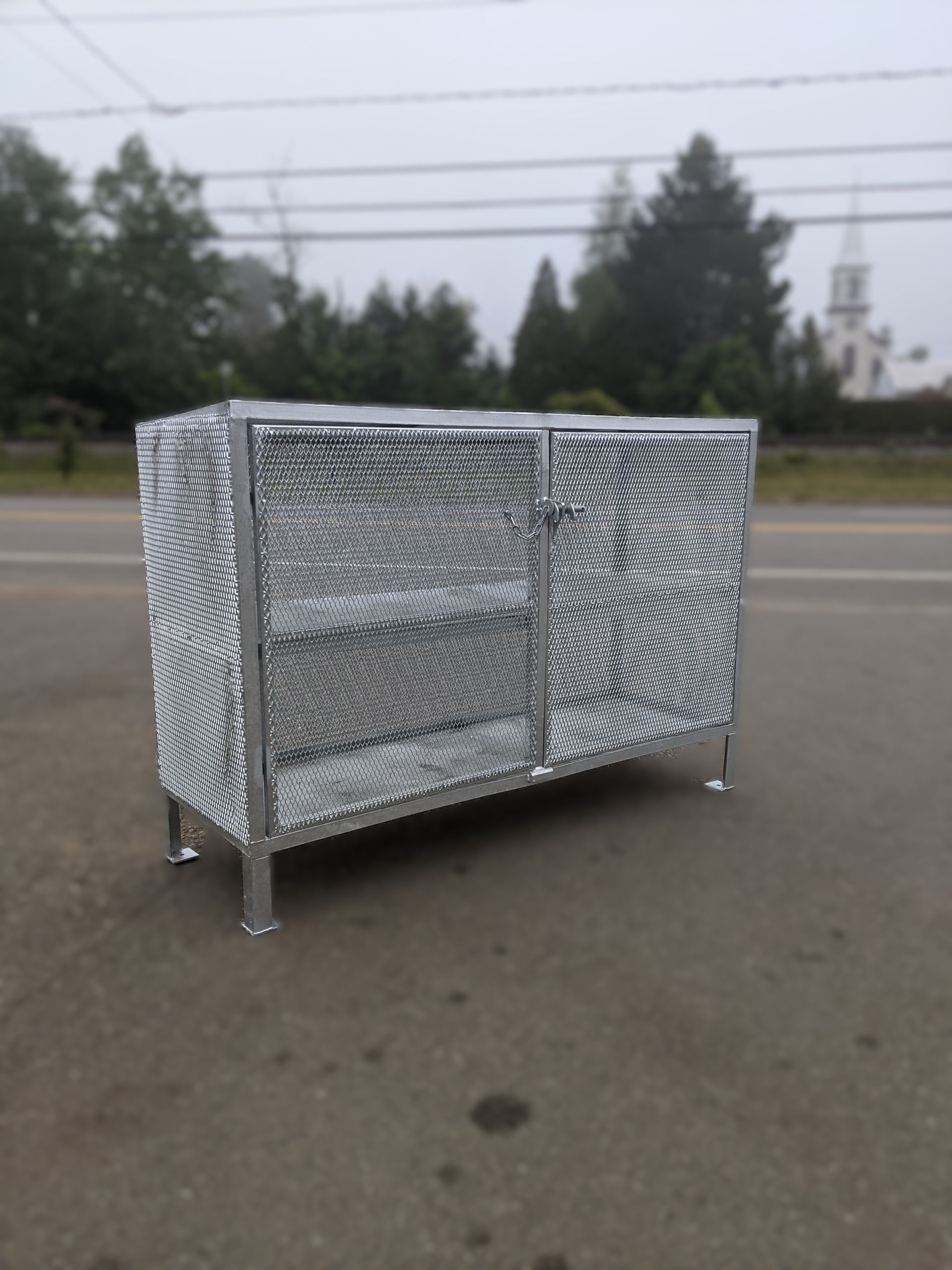 Une armoire métallique se trouve sur le bord de la route.