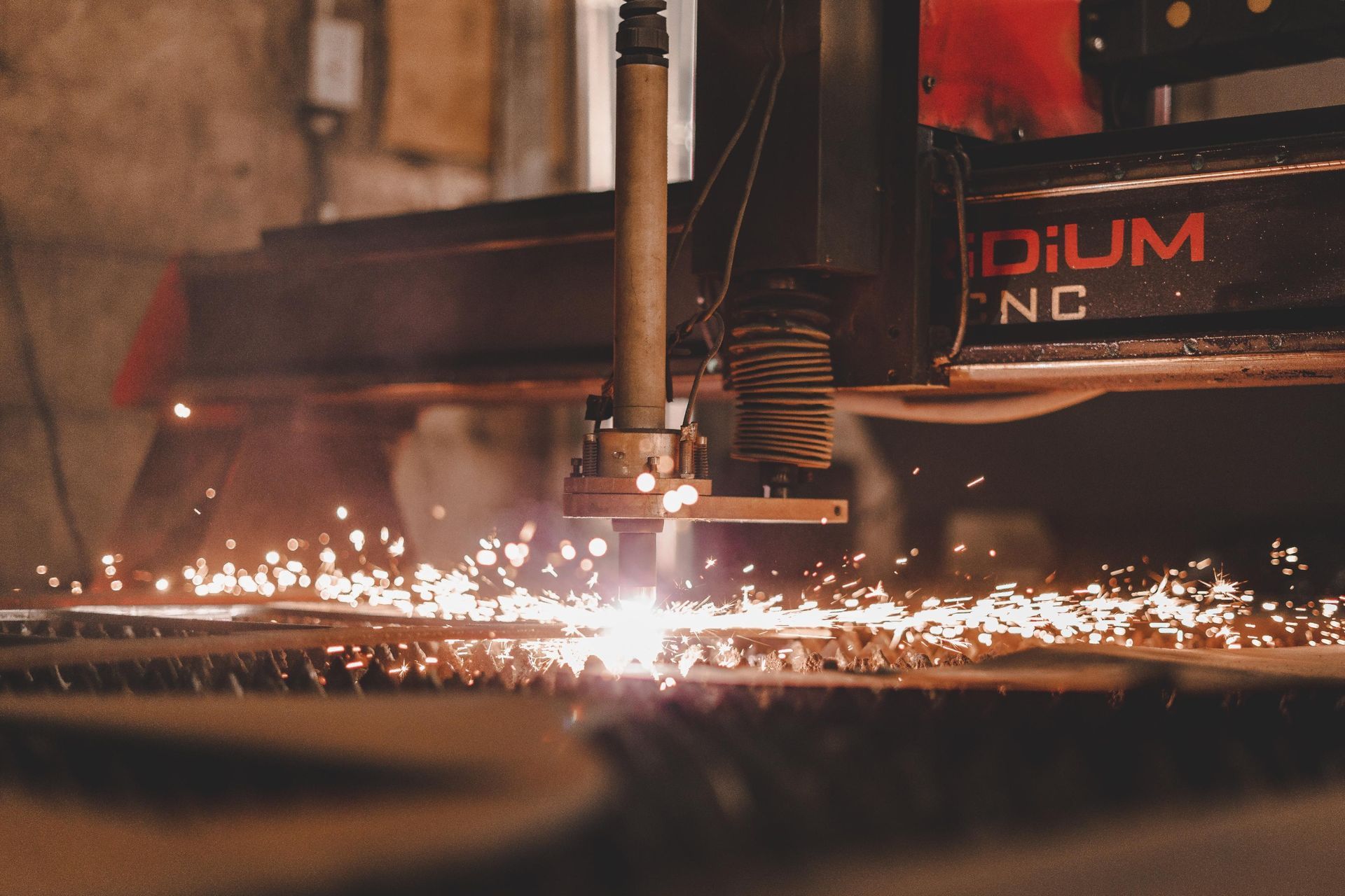 Une machine coupe un morceau de métal et des étincelles en sortent.