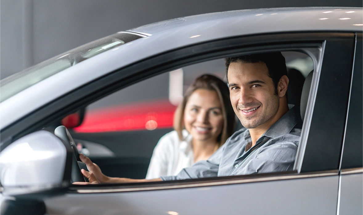 Painel de instrumentos do carro com mãos ajustando os controles de climatização, tela azul.