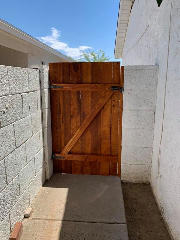 Wooden gate in a narrow passageway between concrete block walls.