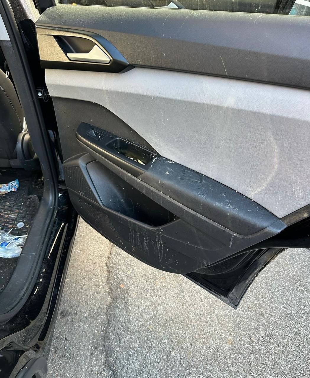 The inside of a car with the door open and the door handle visible.