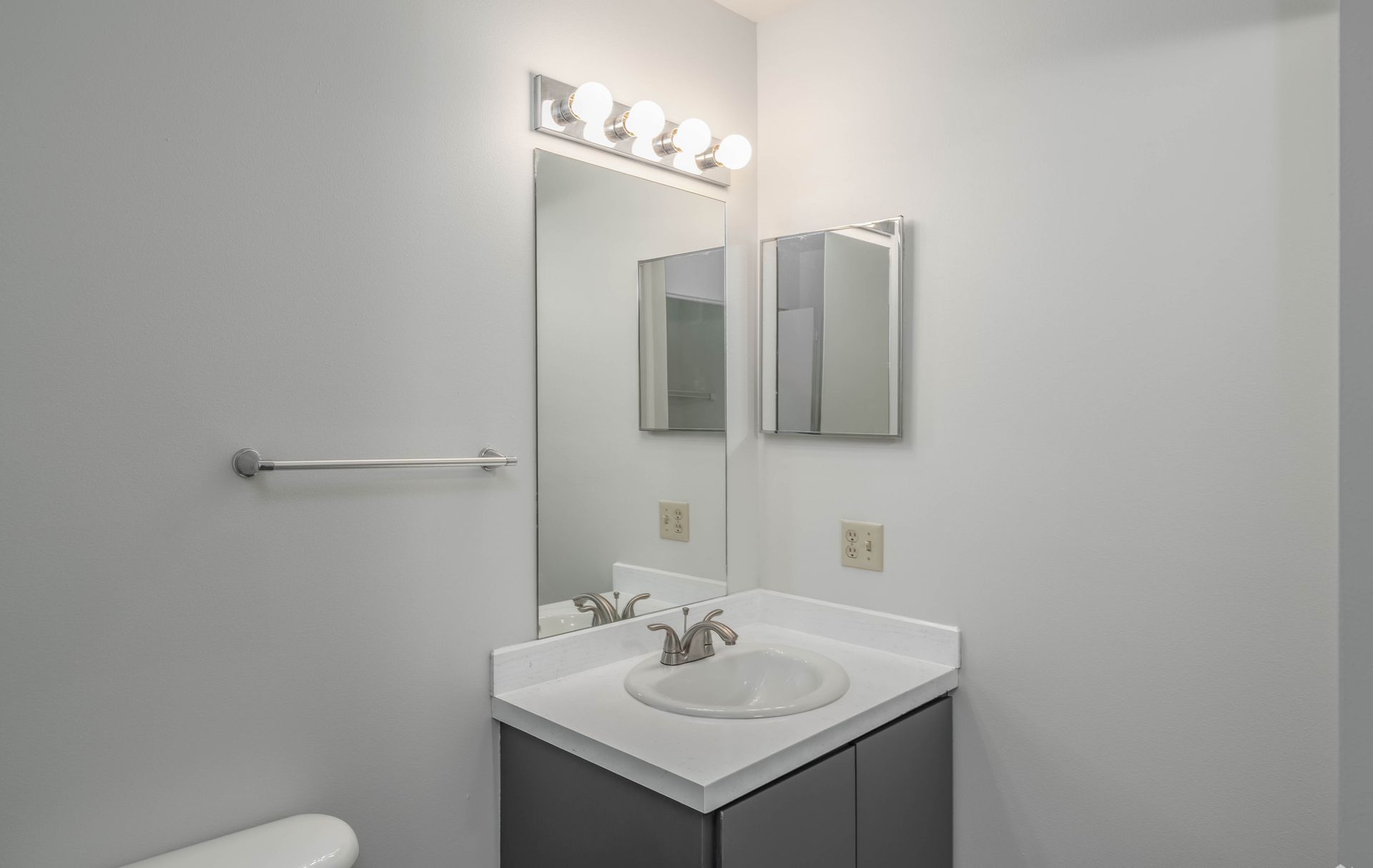 A bathroom with a sink , mirror and toilet.