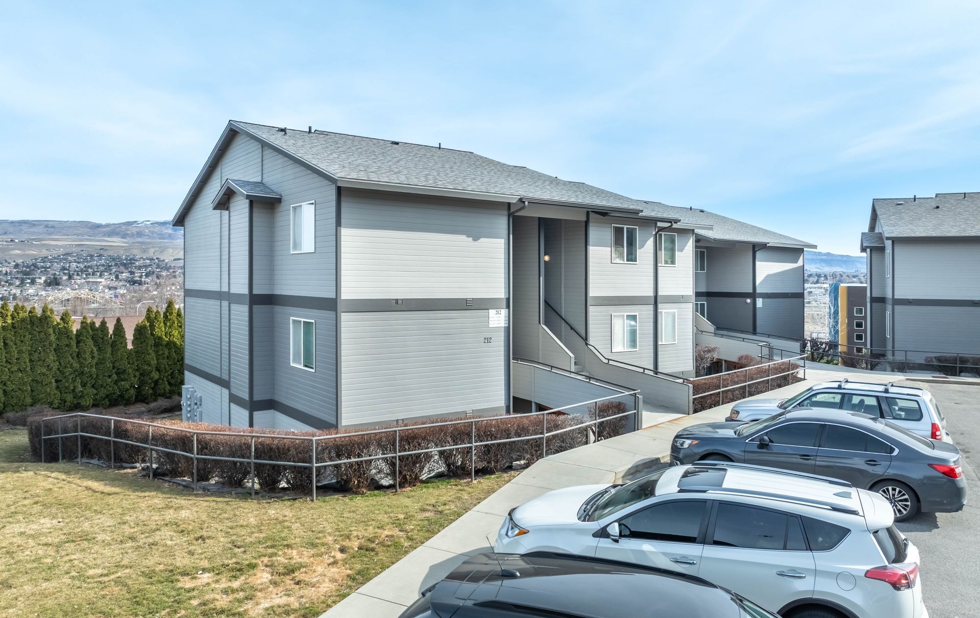 A row of cars are parked in front of a building.
