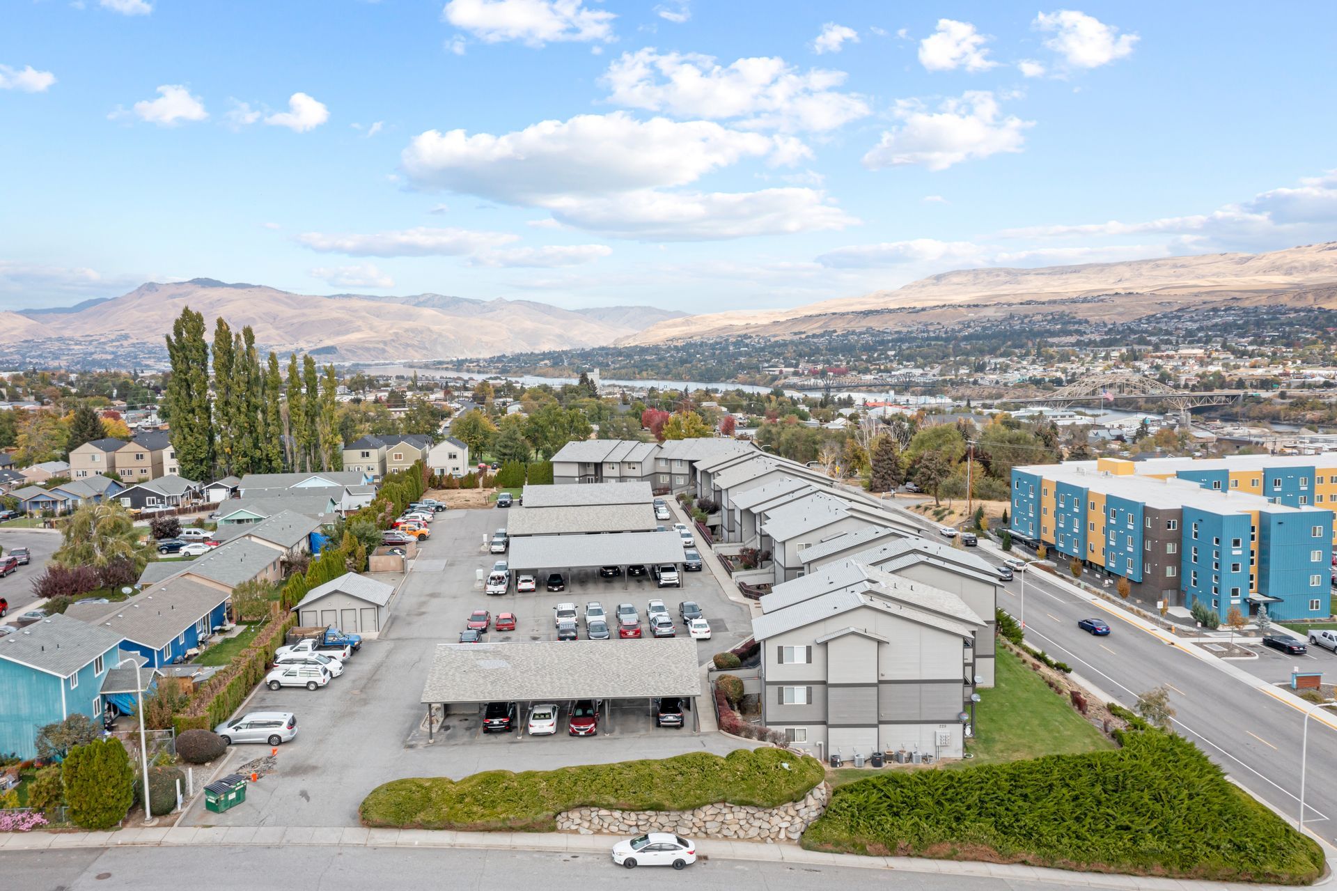 An aerial view of a parking lot with cars parked in front of a building.