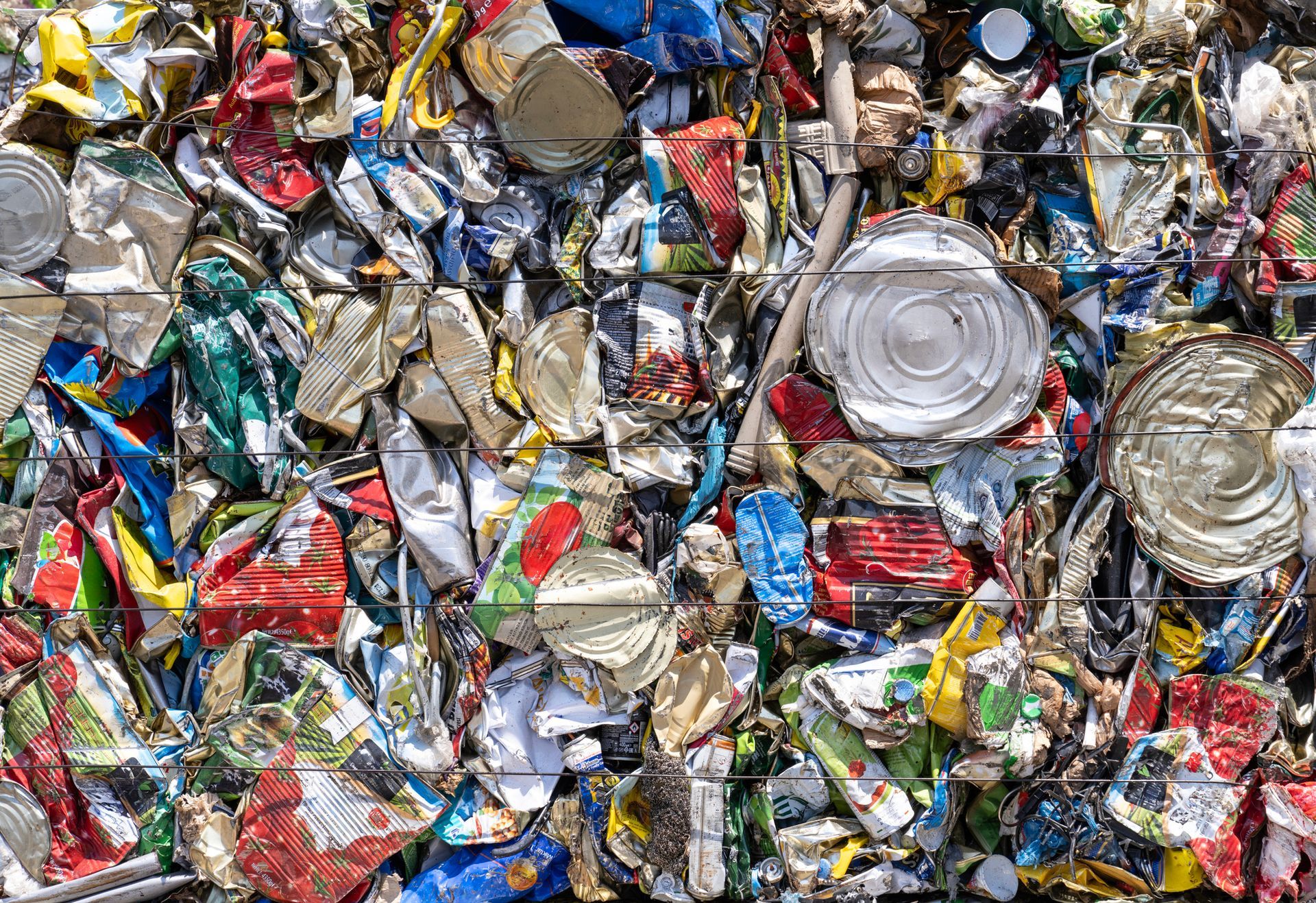 A pile of crushed cans and bottles sitting on top of each other. A pile of crushed cans and bottles sitting on top of each other.