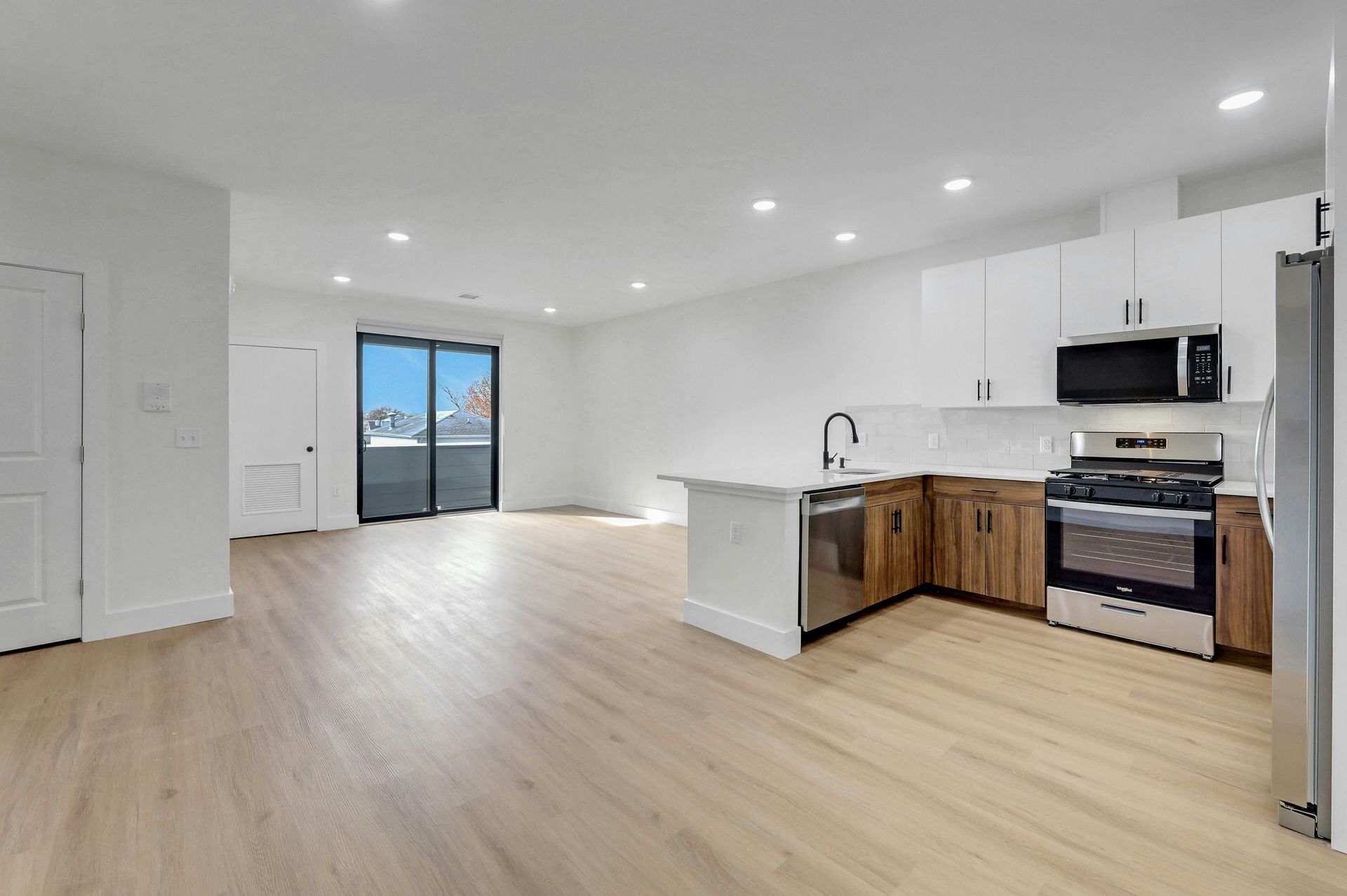 Laundry room with stacked washer/dryer, shelving, and electrical panel.