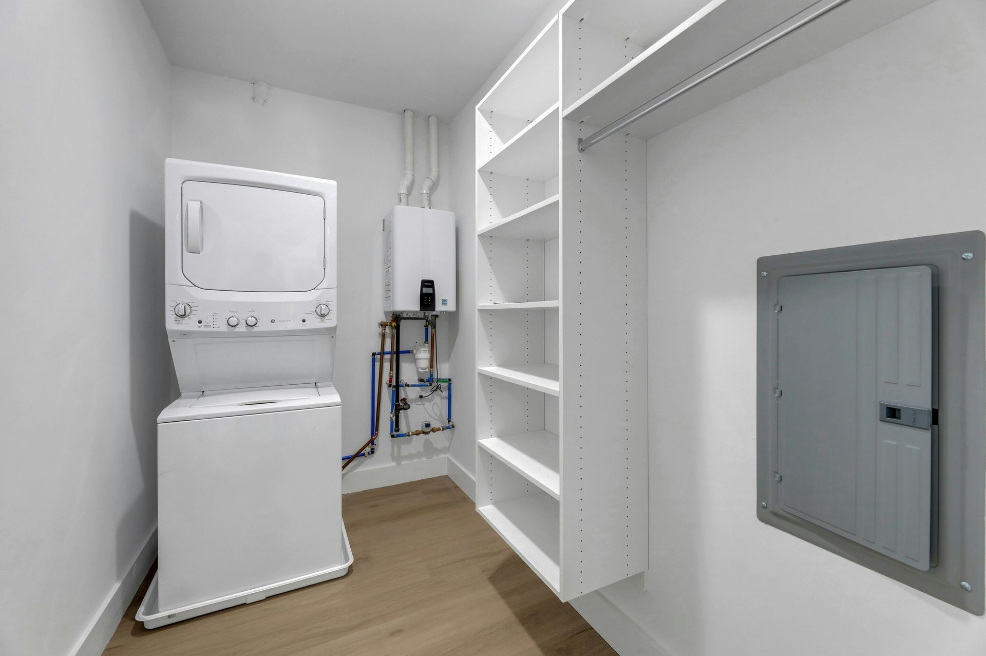 Modern kitchen with white cabinets, stainless steel appliances, and wood flooring.