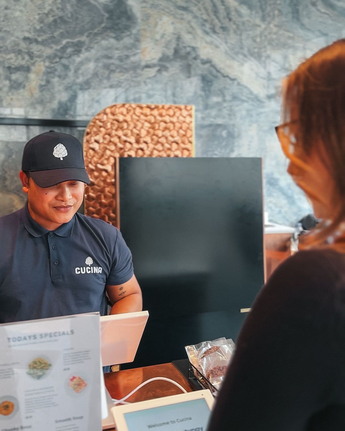 a man wearing a shirt that says escape is talking to a woman