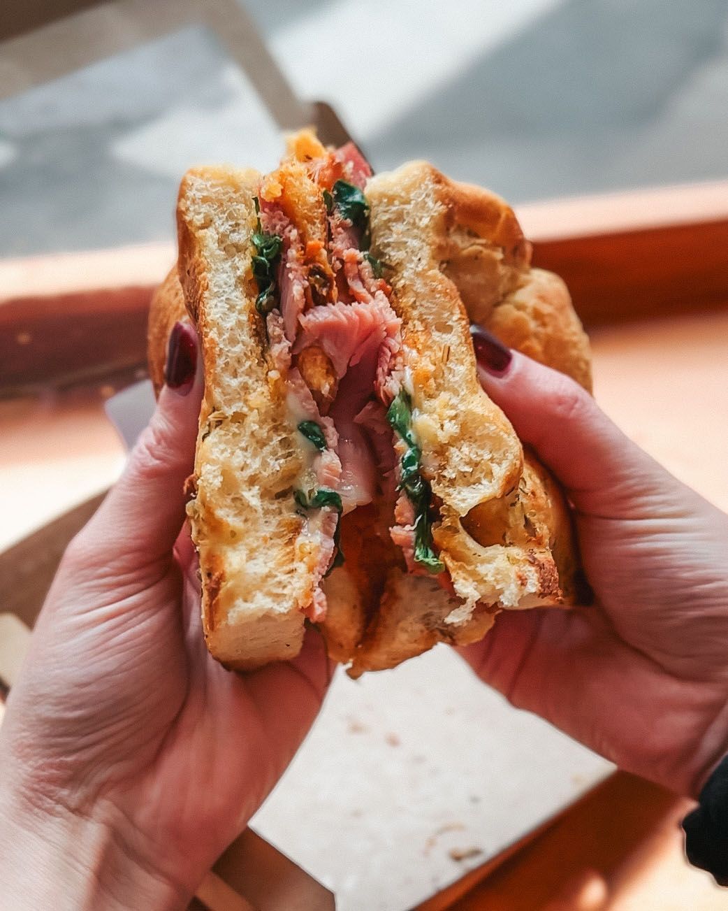 a person is holding a sandwich that has been cut in half