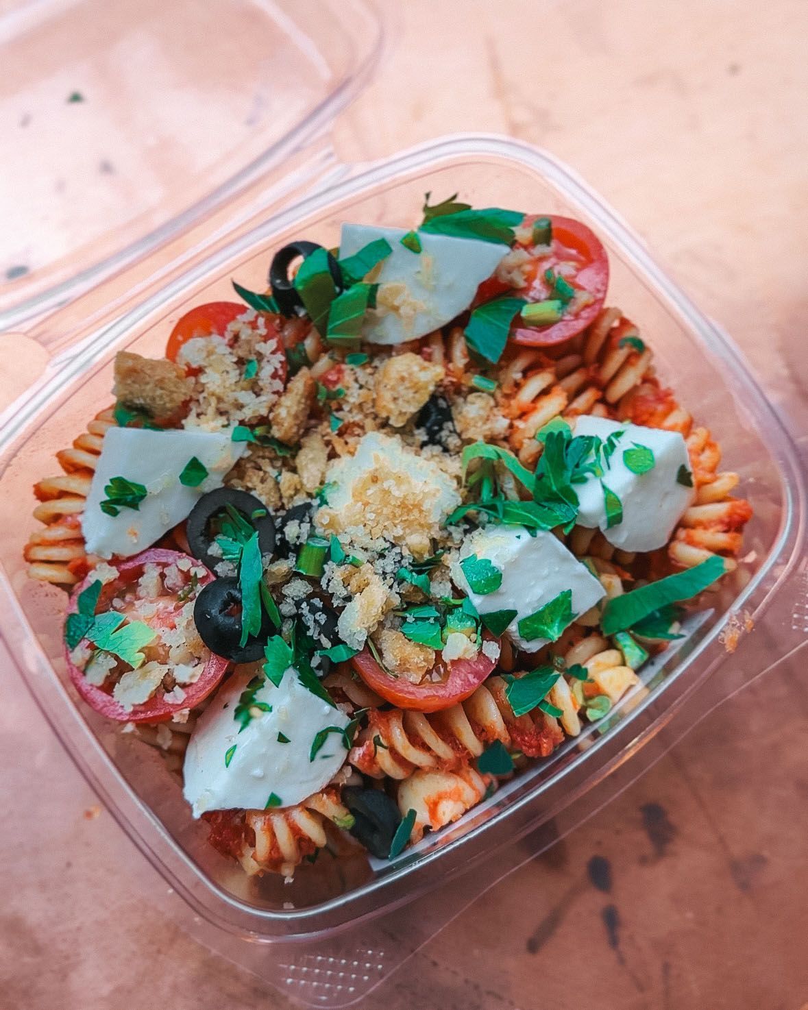 a plastic container filled with pasta and vegetables