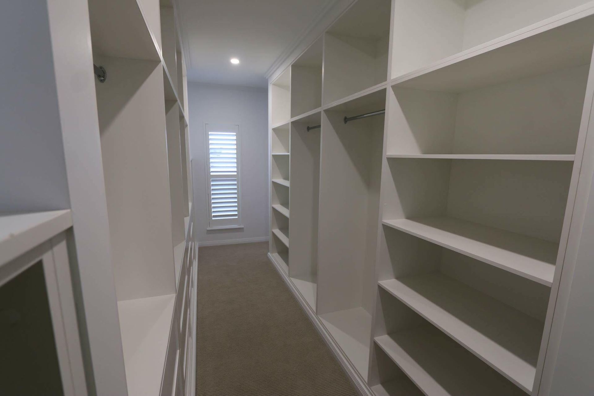 A Walk in Closet With Lots of Shelves and a Window — Ross Joinery Kitchens In Garbutt, QLD