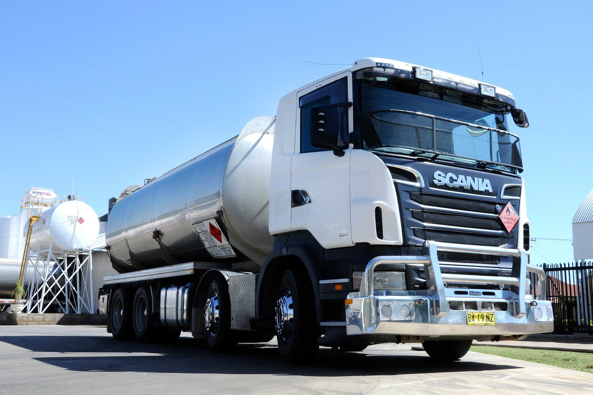 A white scania truck is parked in a parking lot