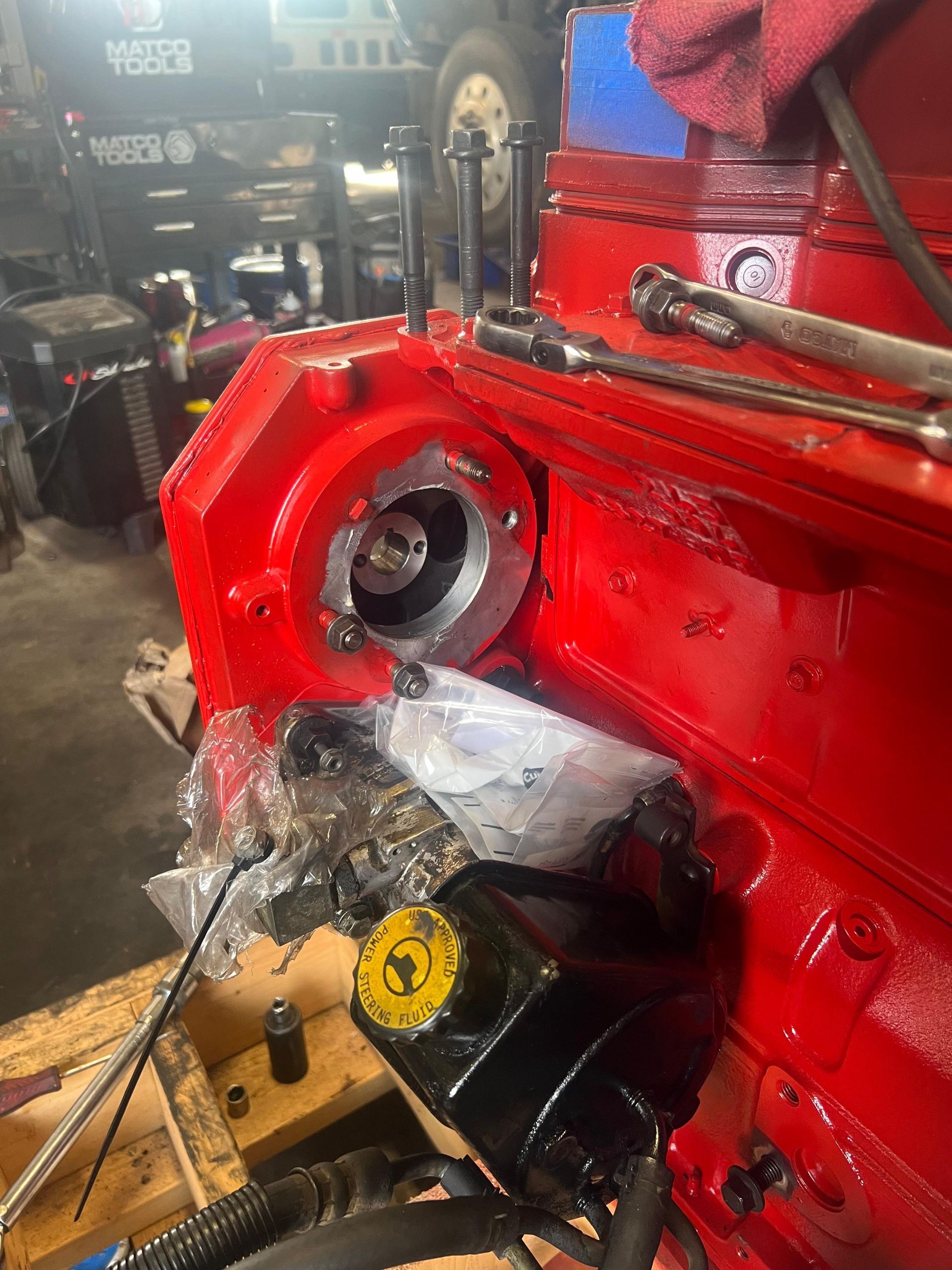 Red engine block with a circular component attached. 