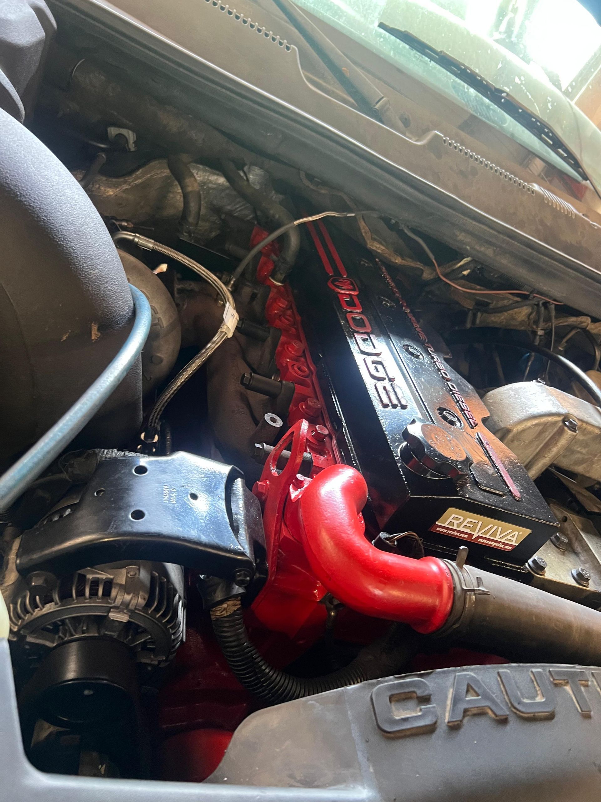 Car engine with red accents and a black cover labeled 