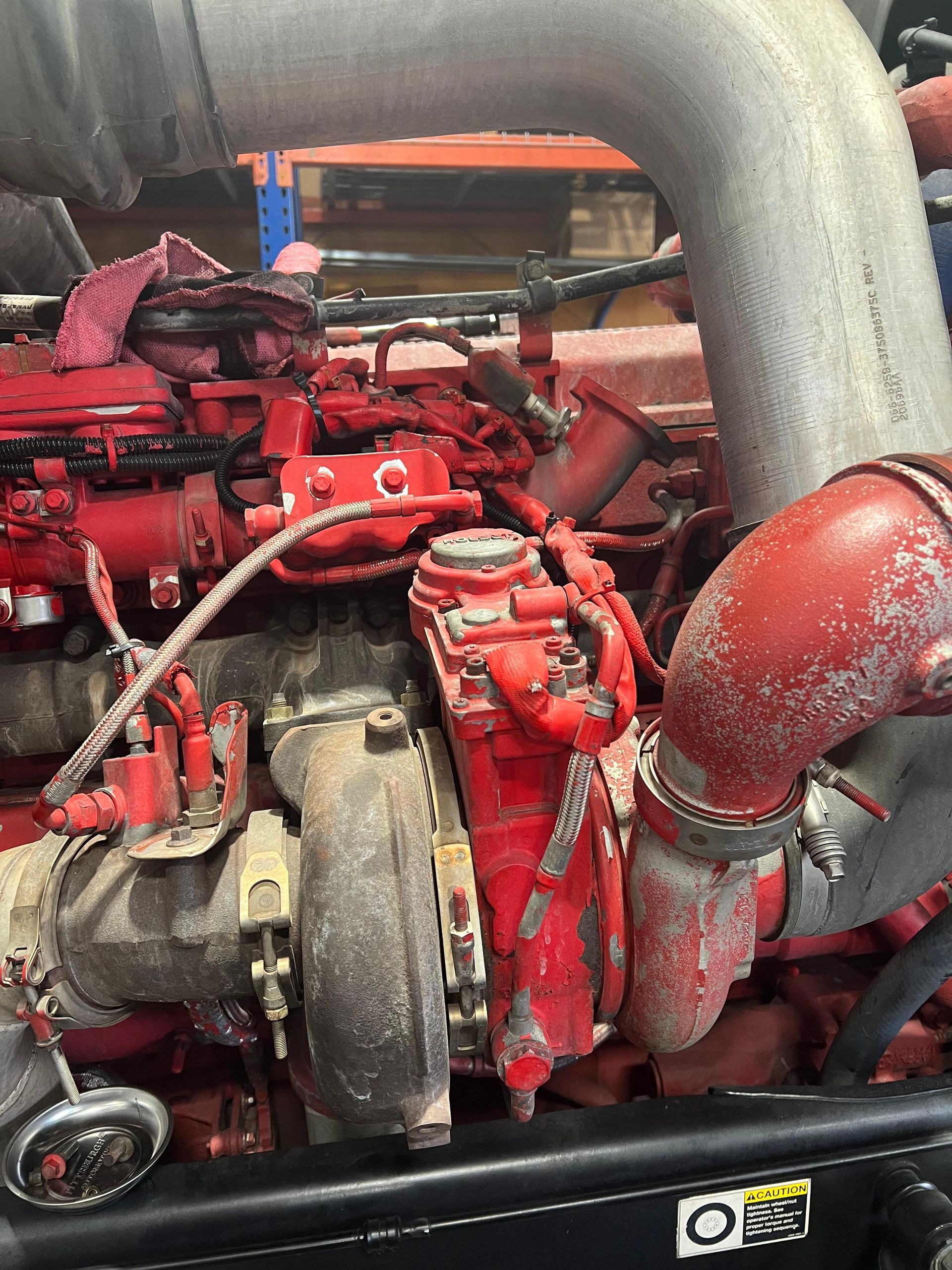 Red and black heavy-duty engine with silver piping, various components and wiring visible.