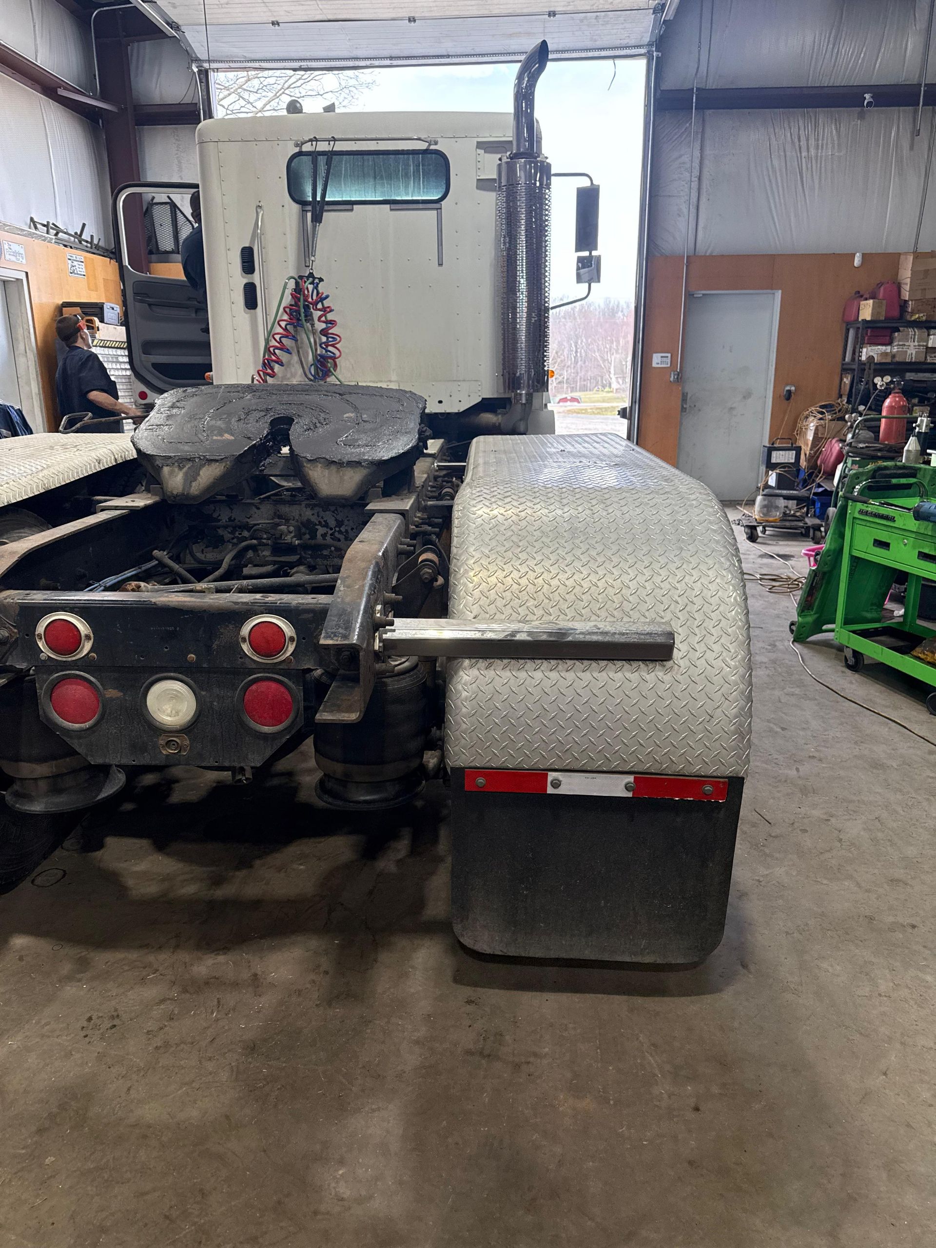 Rear view of a white semi-truck in a garage. 