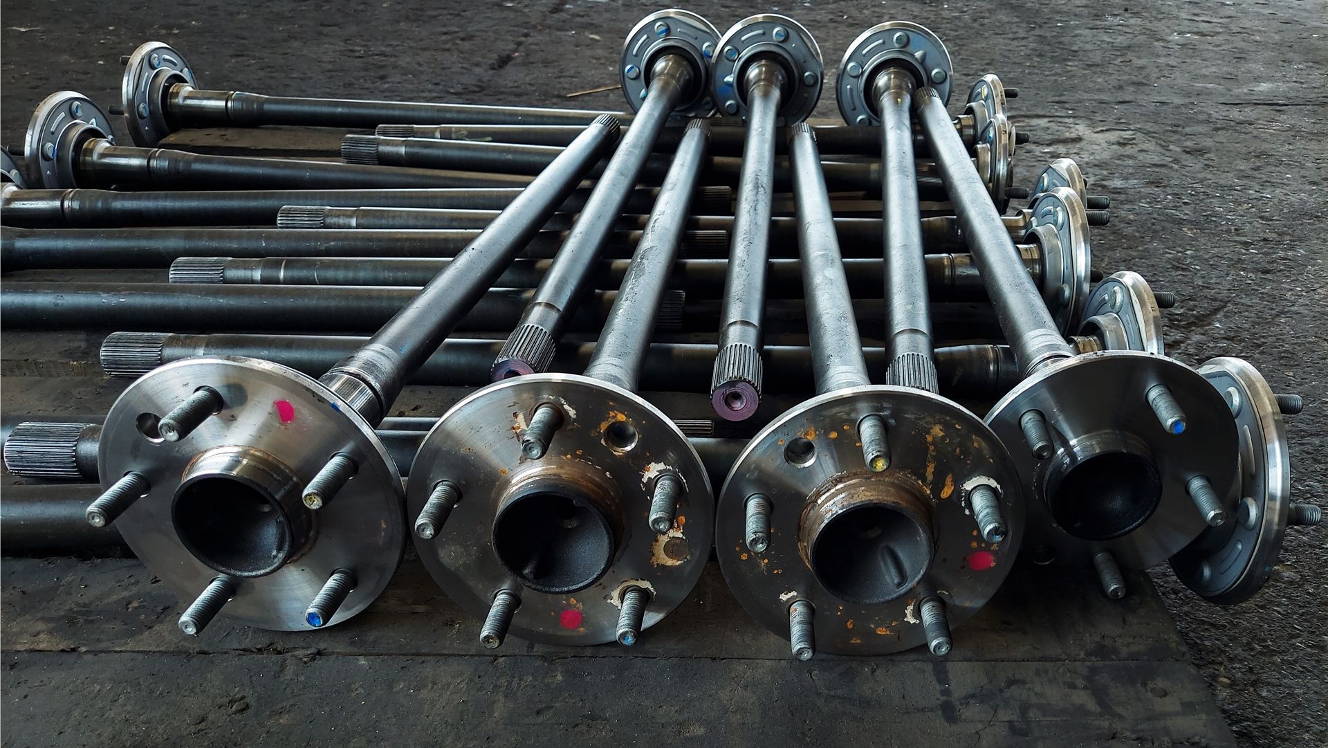 Axle shafts with wheel hubs arranged on a dark surface.