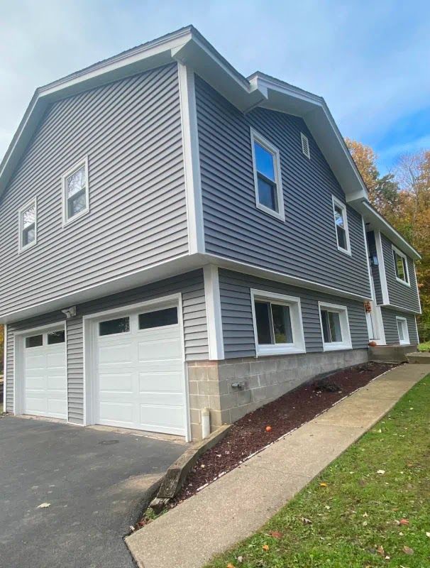 A large house with two garage doors and a ramp leading to it.