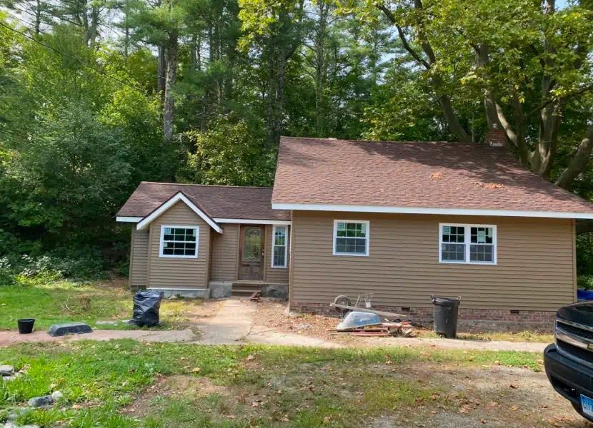 A small house with a car parked in front of it