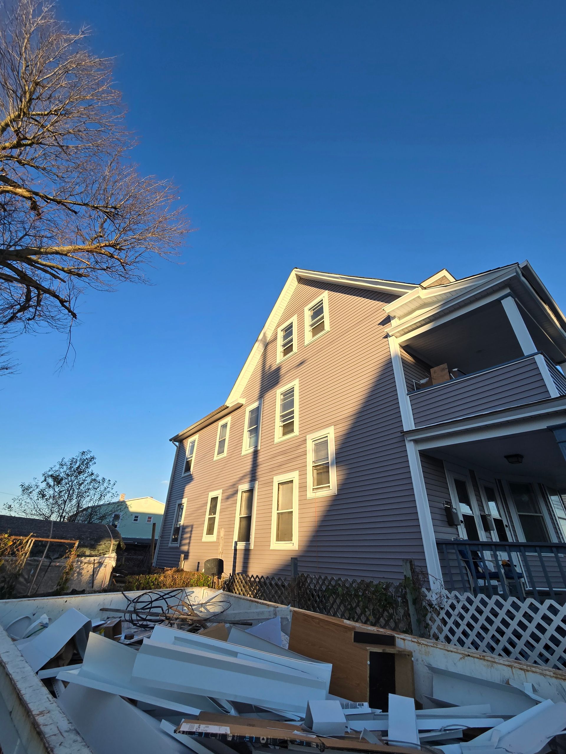 A large house with a blue sky in the background is being demolished.