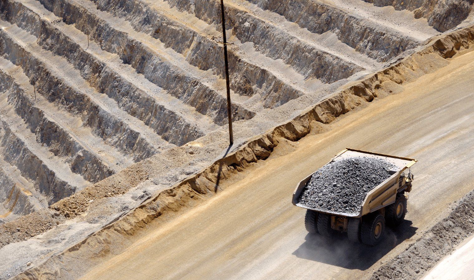A large dumper truck carrying a load of stones through a quarry