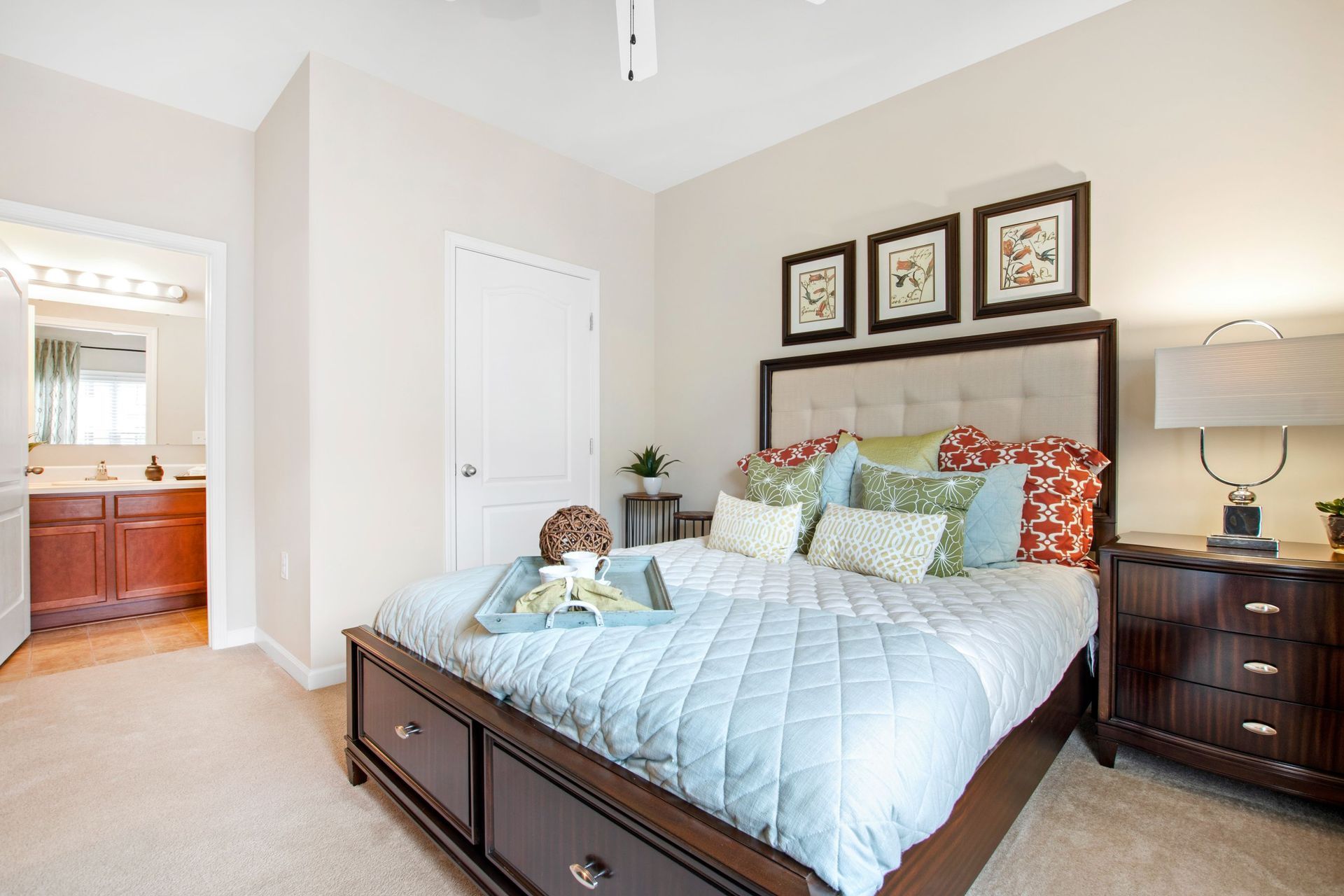 Bedroom in apartment with a dark wood bed, tufted headboard, and matching nightstands at Jack Britt.