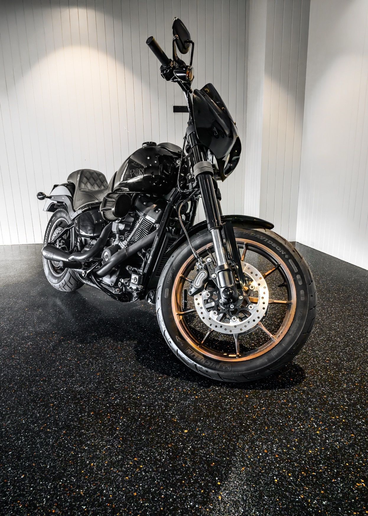 A black motorcycle is parked in a garage.