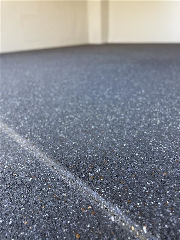 A close up of a black floor with a white line on it.