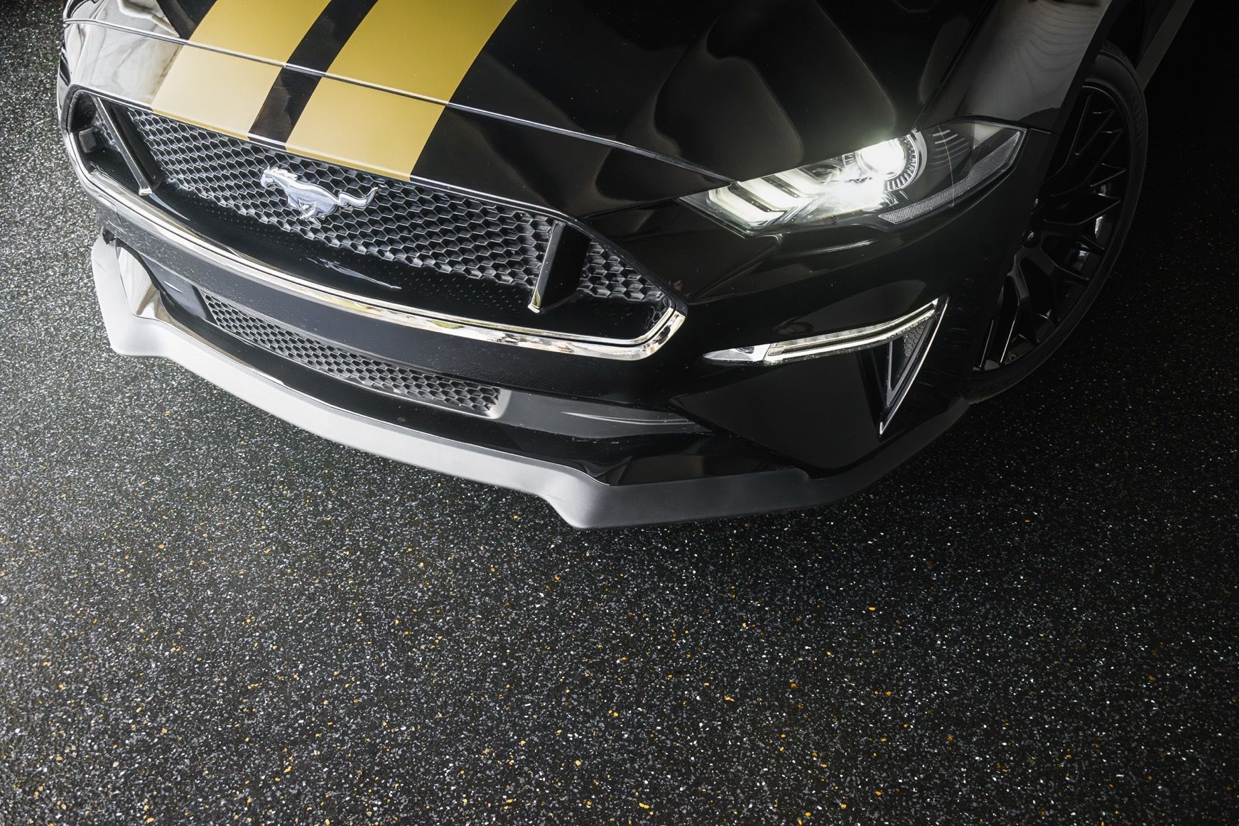 A concrete floor in a garage with bikes hanging on the wall.