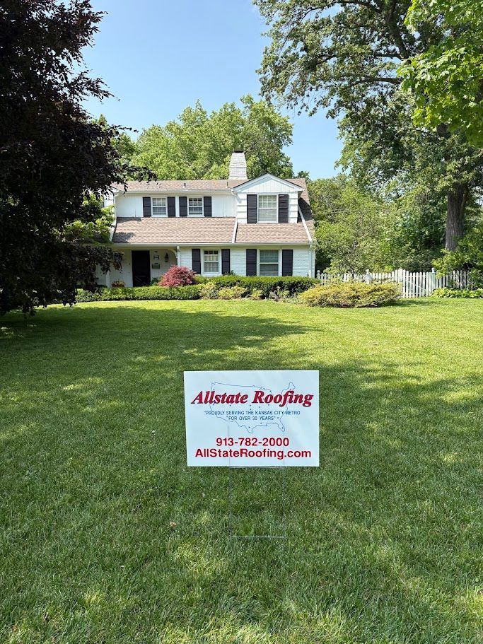 Red barn with a vent on the roof. The roof is silver, and the sky is blue.