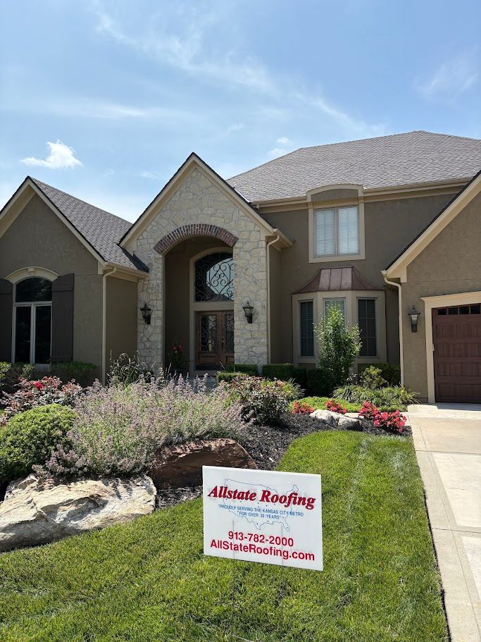 Two-story house with detached garage, brick facade, light brown siding, and dark gray roof.