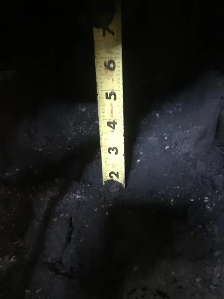 A tape measure is being used to measure a piece of metal.