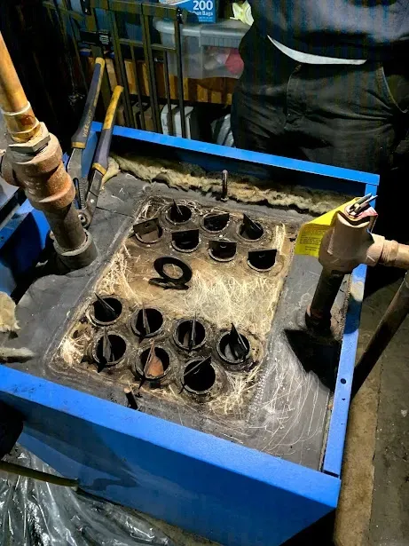 A person is working on a machine with a lot of holes in it.