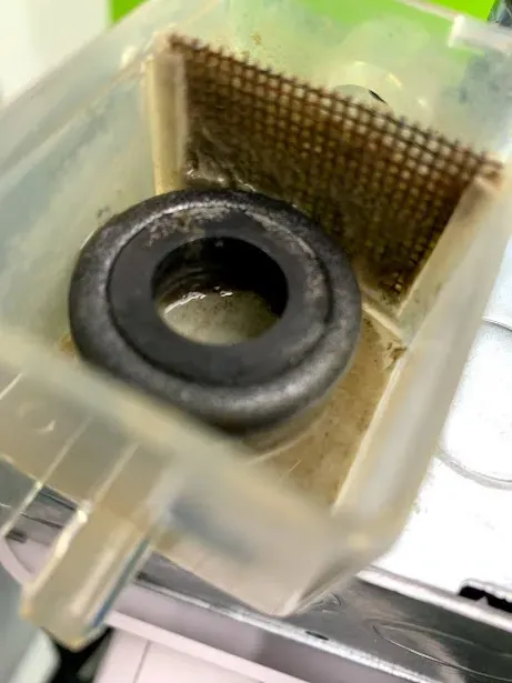 A close up of a plastic container with a metal ring in it.