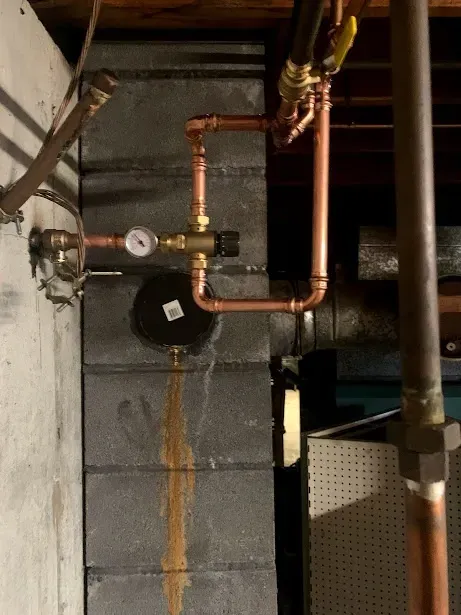 A copper pipe with a gauge attached to it