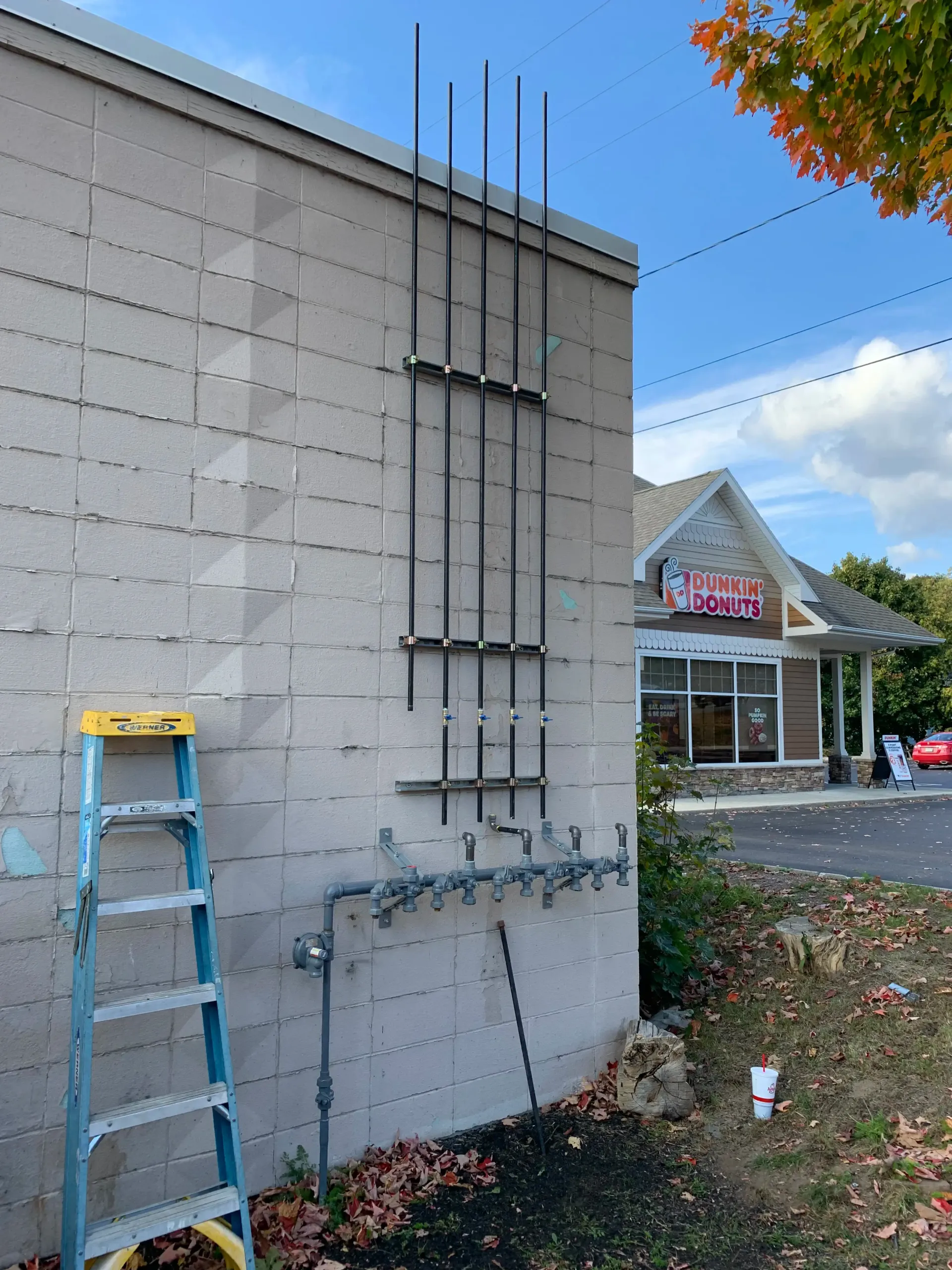 A ladder is sitting on the side of a brick building.