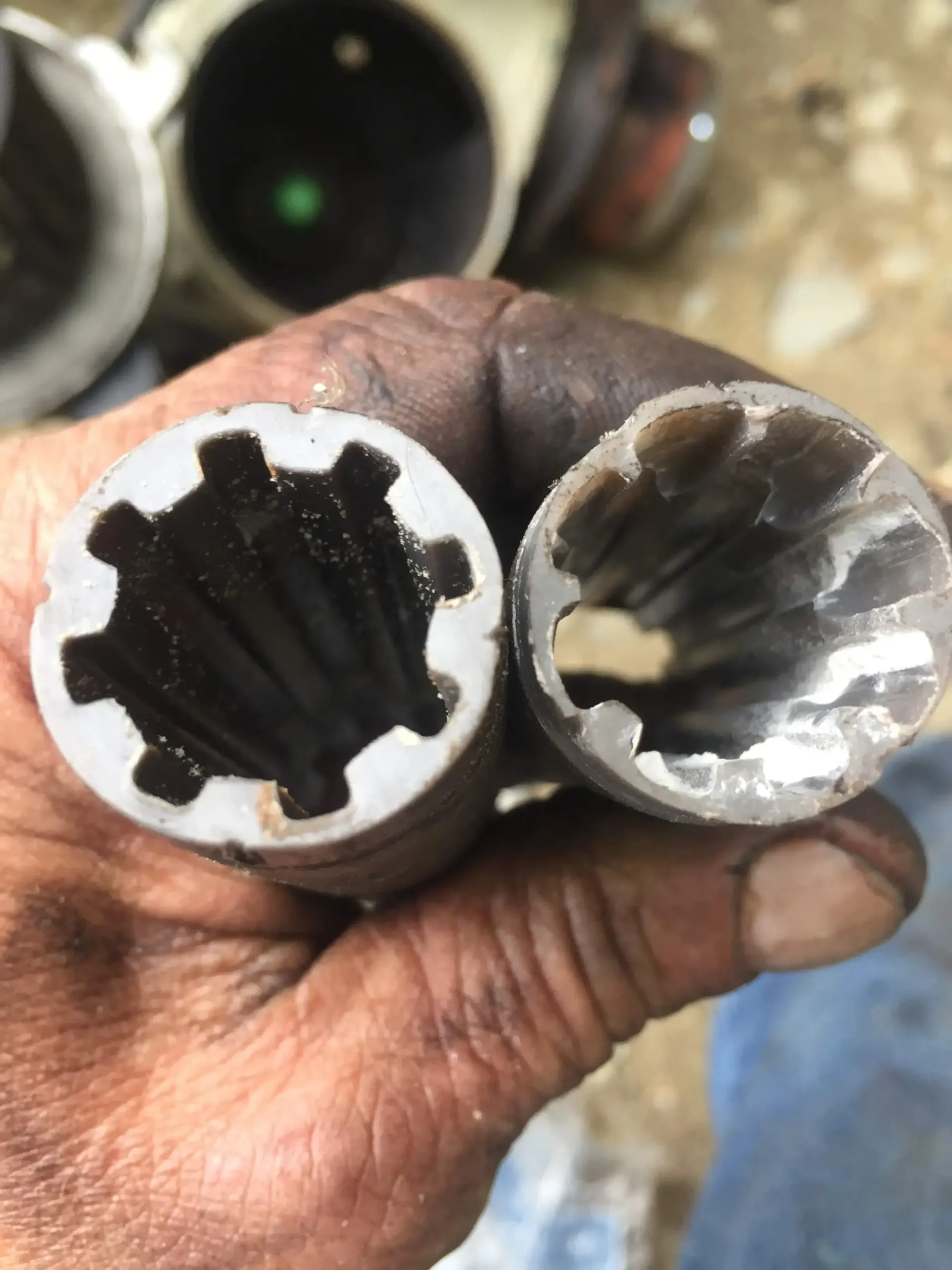 A person is holding two pieces of metal in their hand.