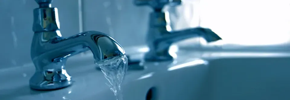 Water is running from a faucet in a bathroom sink.