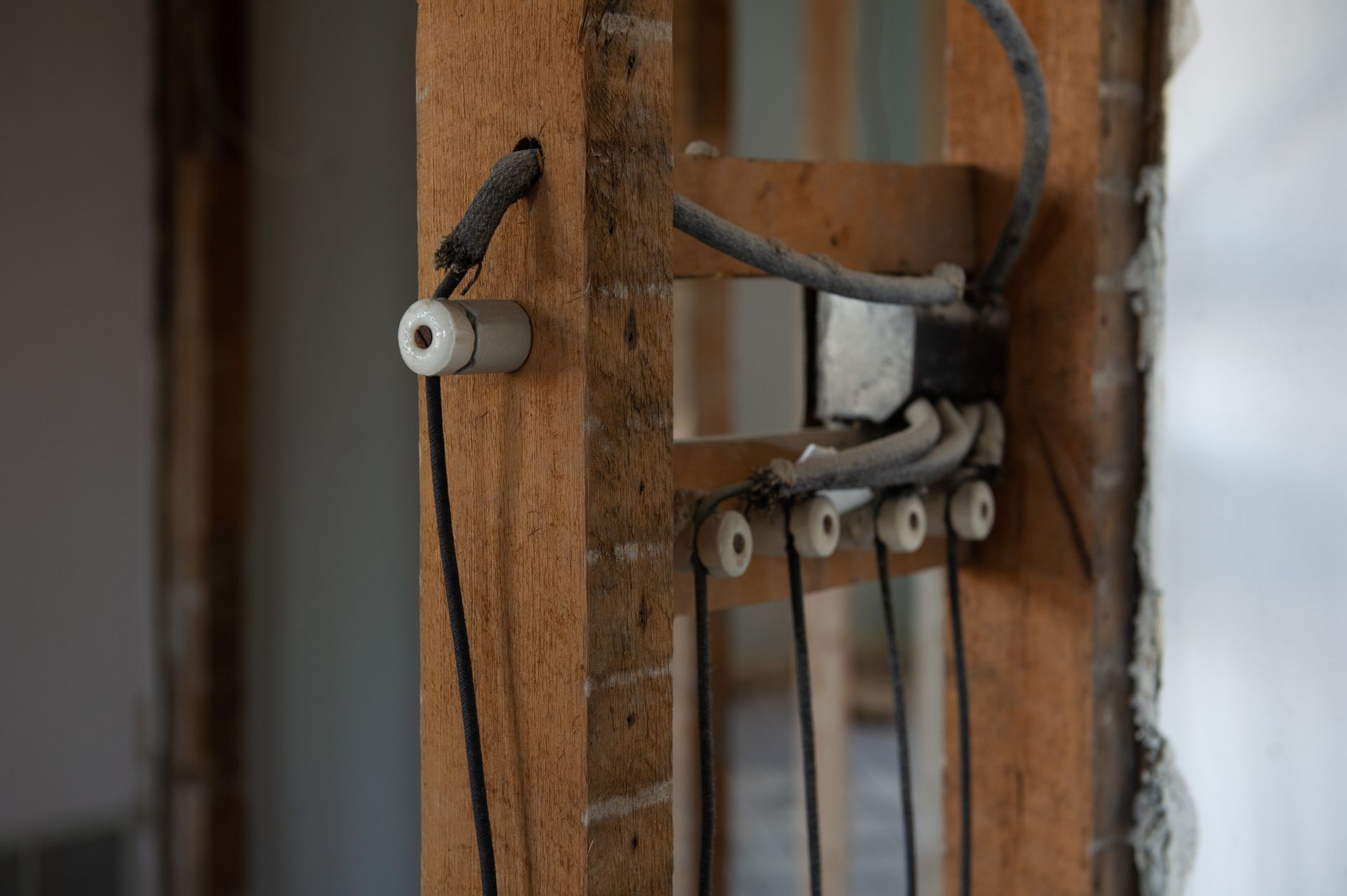 Exposed electrical wiring on a brick and wooden frame in a building during renovation.