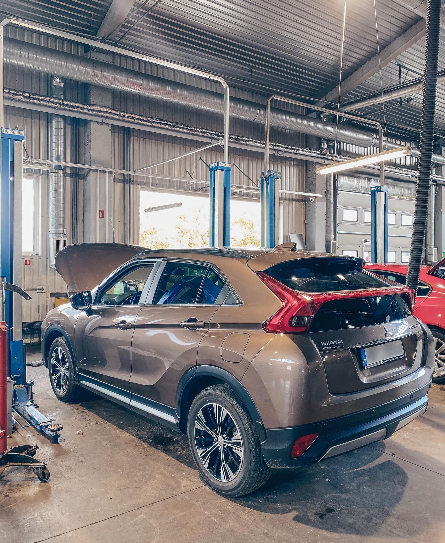 Garāžā uz lifta sēž mašīna.