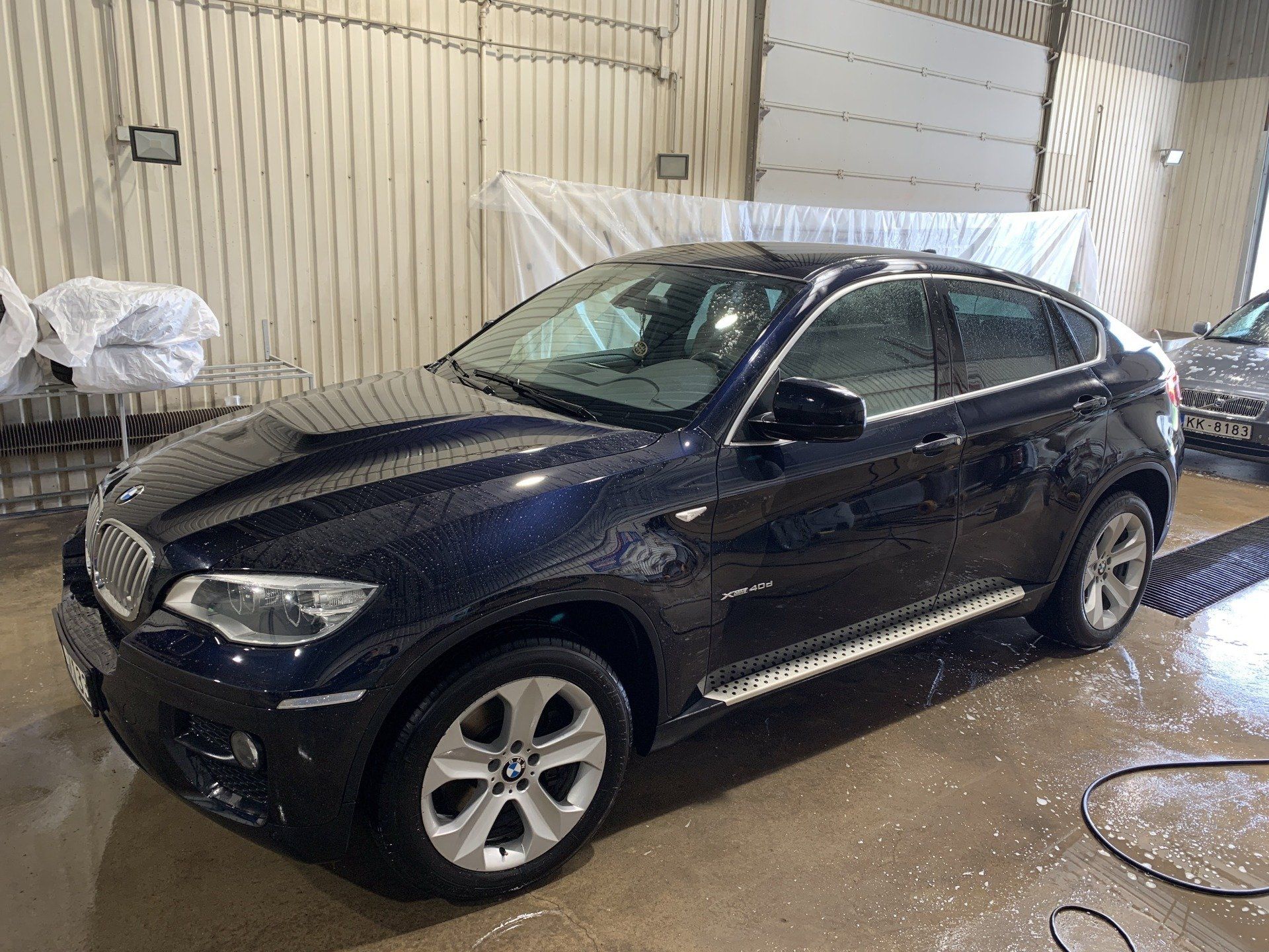 Melns bmw x6 stāv garāžā.